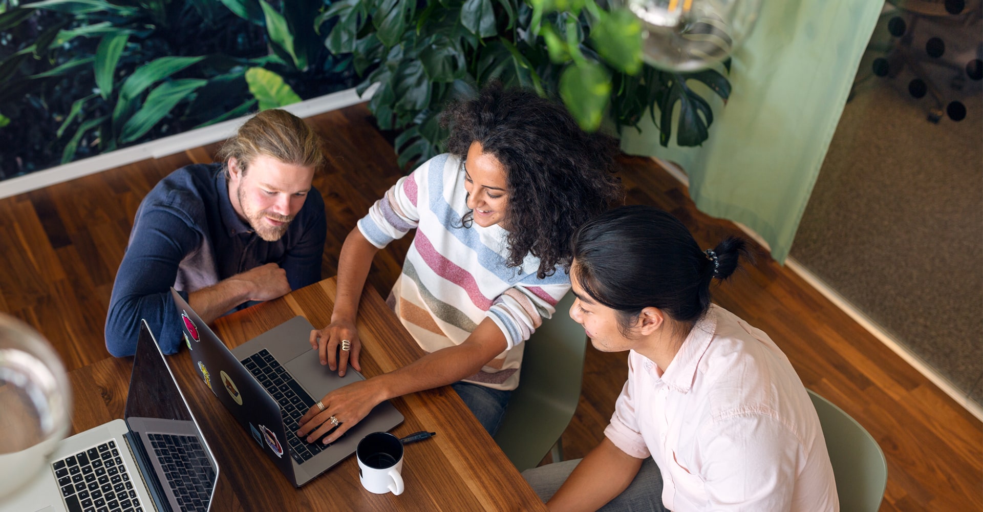 3 people collaborating in front of a laptop