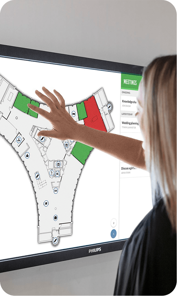 Kvinna bokar ett mötesrum på en Meetio View-touchskärm kartvy