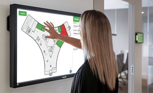 Woman zooming in on a floor plan map on a large screen